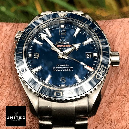 Omega Seamaster Planet Ocean 232.90.42.21.03.001 Blue Dial Near Original Replica omega seamaster planet ocean steel 232 90 42 21 03 001 blue dial replica hand Omega Seamaster Professıonal Co Axial Replica on the man wrist grass background
